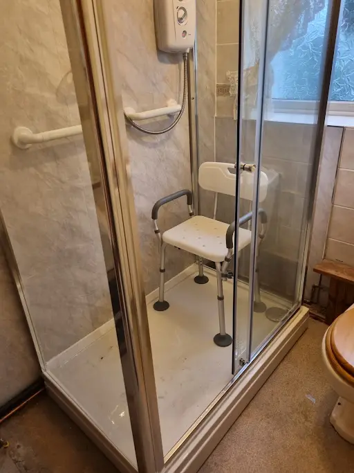 Accessible shower enclosure with grab rails and seat